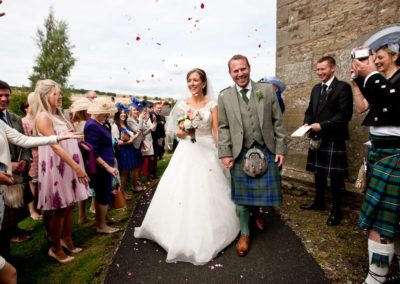 a couple walk through confetti on their wedding day