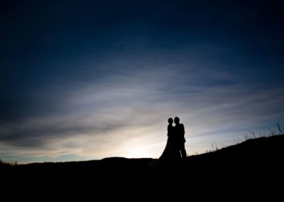 a couple photographed against the sky on their wedding in dunkeld