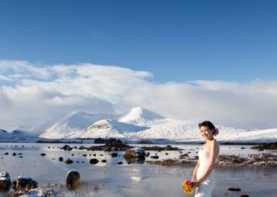 an asian bride stands in the snow in scotland