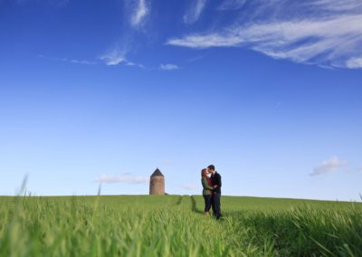 a young couple in love standing in a field in scotland