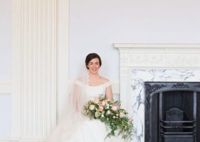 a bridal portrait of a bride sitting next the fireplace at lews castle in stornoway
